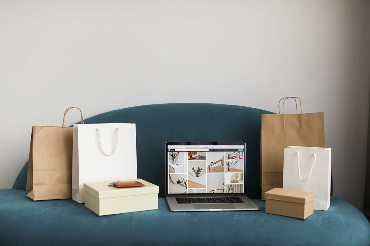 Notebook com embalagens de loja online ao lado - e-commerce operado por agentes de IA da Poupar AI